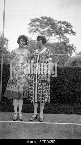 Photographie anglaise vintage des années 1920 en noir et blanc montrant une jeune femme et sa mère, à l'extérieur, posant dans des vêtements à la mode de l'époque. Banque D'Images