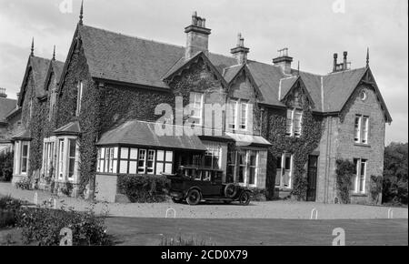 Photographie en noir et blanc des années 1920 montrant une voiture de l'époque, numéro d'immatriculation TS 5466, garée à l'extérieur d'une grande maison à Tayside, en Écosse. Banque D'Images