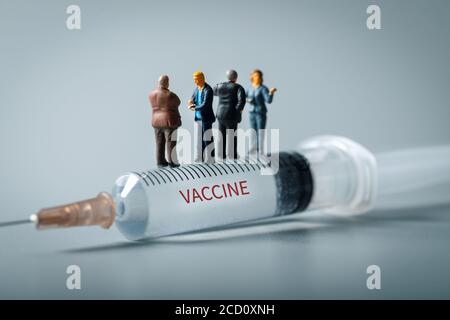 les gens d'affaires de l'industrie médicale debout sur la seringue. nouveau concept d'invention de vaccin Banque D'Images