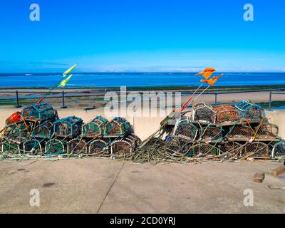 Des casiers à crabe ou homard empilés sur l'Esplanade, où les bateaux de pêche sont stationnés à Redcar North Yorkshire UK Banque D'Images