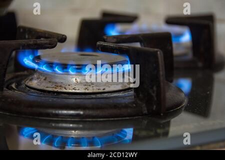Gaz brûlant avec des flammes bleues sur une cuisinière à gaz Banque D'Images
