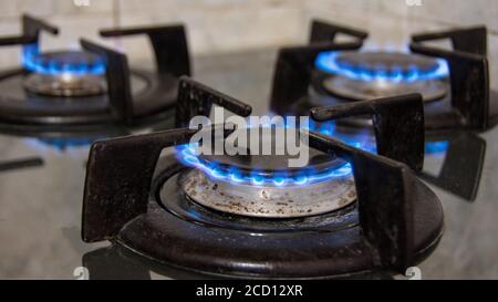 Gaz brûlant avec des flammes bleues sur une cuisinière à gaz Banque D'Images