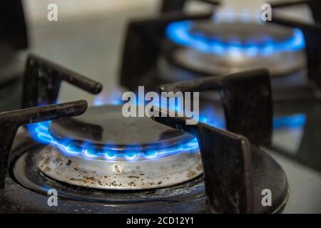 Gaz brûlant avec des flammes bleues sur une cuisinière à gaz Banque D'Images