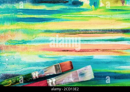 Toile peinte brillante d'artiste et de pinceaux artistiques sales, texture de peintures à l'huile artistique mixtes, différentes couleurs, taches de mélange, taches, créativité moderne Banque D'Images