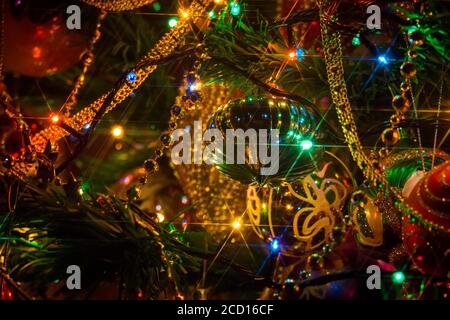 Sapin de noël artificiel décoré de lumières colorées illuminant la nuit. Banque D'Images