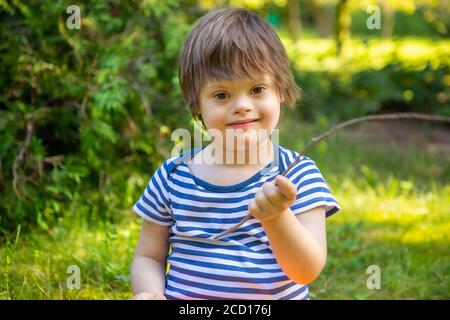 Portrait de bébé garçon avec le syndrome de Down jouant en été jour sur la nature Banque D'Images