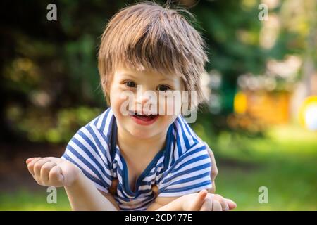 Portrait de bébé garçon avec le syndrome de Down jouant en été jour sur la nature Banque D'Images