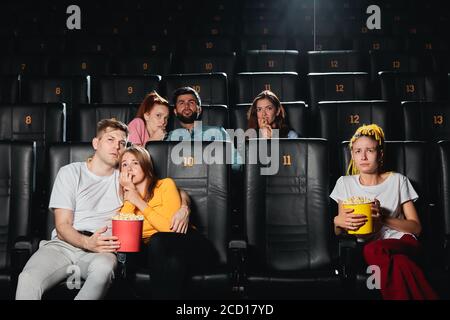 un couple effrayé se penchait l'un sur l'autre tout en étant assis au cinéma, concept de réaction Banque D'Images