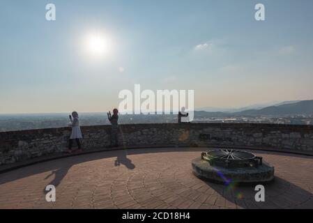 Egyptiennes avec smartphon sur le toit-terrasse avec vue aérienne de la vieille ville italienne de Brescia. Banque D'Images