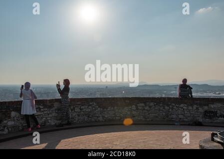 Egyptiennes avec smartphon sur le toit-terrasse avec vue aérienne de la vieille ville italienne de Brescia. Banque D'Images