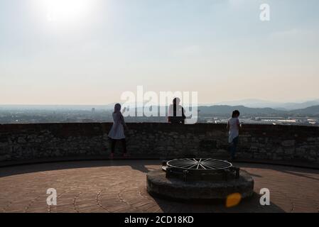 Egyptiennes avec smartphon sur le toit-terrasse avec vue aérienne de la vieille ville italienne de Brescia. Banque D'Images