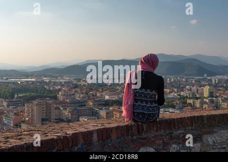 Fille égyptienne avec smartphon sur le toit-terrasse avec vue aérienne de la vieille ville italienne Brescia. Banque D'Images