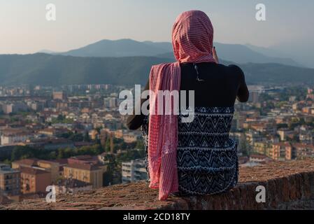 Fille égyptienne avec smartphon sur le toit-terrasse avec vue aérienne de la vieille ville italienne Brescia. Banque D'Images