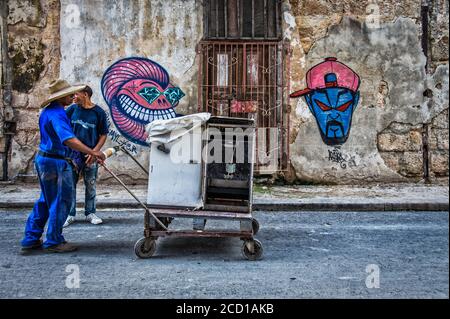 La Havane, Cuba, juillet 2019, un motionnaire transportant un petit réfrigérateur et une cuisinière sur un chariot parlant à un homme au milieu de la rue Banque D'Images