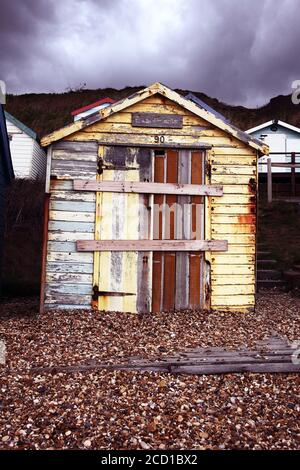 Il a été délabré et vieillissé, sombre et vieux, hutte de plage rustique en bois par mauvais temps. Abandonné depuis longtemps et monté à bord. Banque D'Images