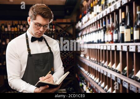 Le sommelier de l'hôtel s'assortira au choix du vin du client Son goût vintage et de donner des échantillons de différentes spécialités dans restaurant Banque D'Images