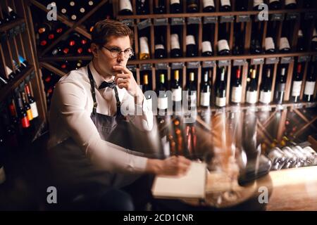 Le sommelier de l'hôtel s'assortira au choix du vin du client Son goût vintage et de donner des échantillons de différentes spécialités dans restaurant Banque D'Images