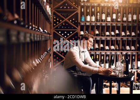 Le sommelier de l'hôtel s'assortira au choix du vin du client Son goût vintage et de donner des échantillons de différentes spécialités dans restaurant Banque D'Images