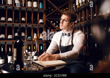 Le sommelier de l'hôtel s'assortira au choix du vin du client Son goût vintage et de donner des échantillons de différentes spécialités dans restaurant Banque D'Images