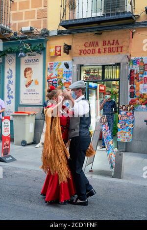 Couple Chulapo dansant devant une épicerie colorée au coin de la Calle de la Cava Baja, La Latina, Madrid, août 2020 Banque D'Images