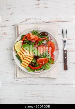 Salade délicieuse avec fromage halloumi grillé, laitue, tomates, poivron, oignon rouge, olives Kalamata, huile d'olive, basilic, citron et épices. Mediterr Banque D'Images