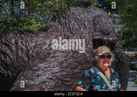 New York, États-Unis. 25 août 2020. Le tourisme pose à côté de la sculpture massive de gorilles par Gillie et Marc Schattner dans le parc Bella Abzug de Hudson yards. Le nouveau travail, intitulé le roi Nyani (mot swahili pour gorilla) est capable d'adapter de façon impressionnante deux à trois humains à l'intérieur de sa main. Crédit : John Nacion/SOPA Images/ZUMA Wire/Alay Live News Banque D'Images