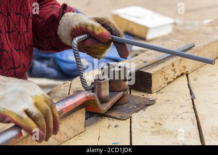 Barre d'armature métallique de flexion. Employé utilisant une machine à barre d'armature pour le renforcement dans les travaux de construction Banque D'Images