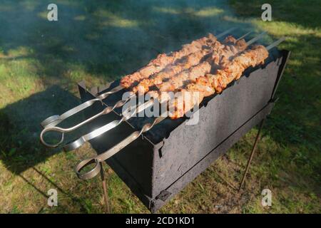 Préparation des brochettes marinées au barbecue sur charbon de bois. Banque D'Images