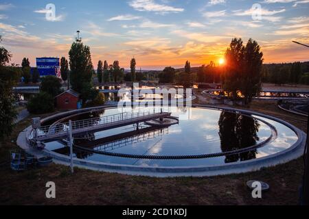 Usine moderne de traitement des eaux usées. Réservoirs de purification des eaux usées au coucher du soleil, vue aérienne Banque D'Images