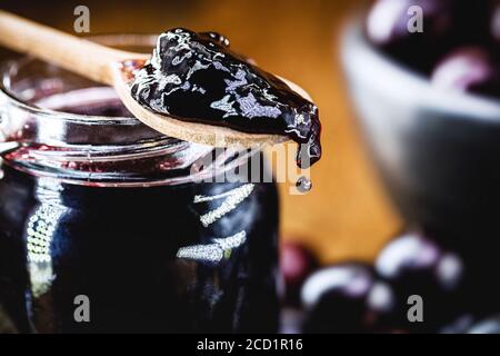 Gelée biologique faite dans une cuillère en bois, jabuticaba (ou jaboticaba) gelée, un fruit brésilien typique, connu sous le nom de raisin brésilien, goutte de CA savoureux Banque D'Images