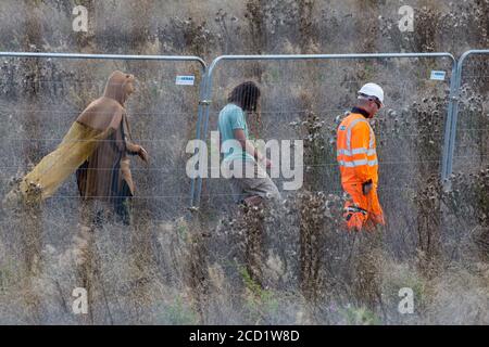 Offchurch, Royaume-Uni. 24 août 2020. Un travailleur de HS2 surveille les activistes anti-HS2 pendant l'abattage d'arbres travaille à côté de la voie Fosse en liaison avec la liaison ferroviaire à grande vitesse HS2. Le projet controversé d'infrastructure HS2 devrait actuellement coûter 106 milliards de livres sterling et détruire ou impacter de manière significative de nombreux habitats naturels irremplaçables, dont 108 anciennes terres boisées. Crédit : Mark Kerrison/Alamy Live News Banque D'Images