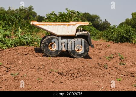 Camion-benne de jouets sur la terre d'une ferme. Banque D'Images