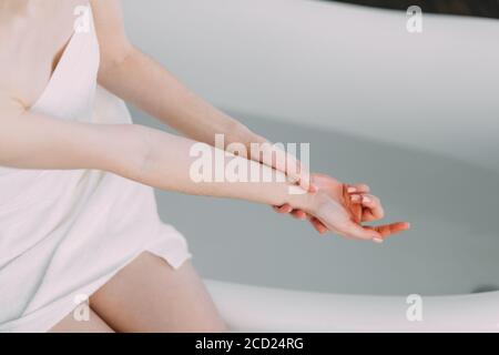 Routine matinale de beauté rouge dans la salle de bains. Femme courant bain, veut se rafraîchir dans l'eau. Banque D'Images