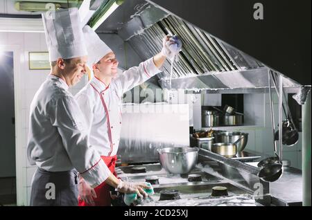 Jour sanitaire dans le restaurant. Lavez vos répétitions de travail. Laver cuisine four, cuisinière et hotte dans le restaurant. Banque D'Images