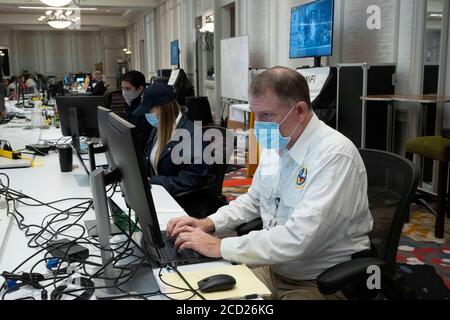 Austin, TX USA 25 août 2020 : des employés de l'État portant des Mas au centre des opérations d'urgence du Texas pendant les préparatifs de l'ouragan Laura, dont la chute est prévue jeudi sur la côte est du Texas et sud-ouest de la Louisiane. Crédit : Bob Daemmrich/Alay Live News Banque D'Images