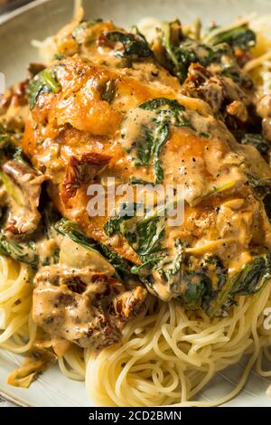 Poulet italien toscan crémeux maison avec épinards et pâtes Banque D'Images