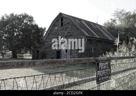 Une ancienne grange en bois se dresse dans un champ d'Oklahoma après des décennies de chaleur, d'humidité, de glace, de pluie et de neige. Banque D'Images