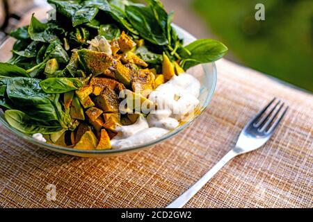 Сhick bol à salade de petits pois avec tomates, feuilles de basilic vert frais et avocat. Arrière-plan marron.vue en gros plan Banque D'Images