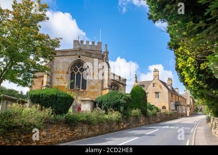 Église Saint-Laurent, maisons et route principale à Bourton sur la colline, Cotswolds, Gloucestershire, Angleterre Banque D'Images