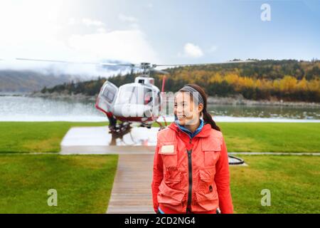 Bonne femme touristique en hélicoptère sur l'excursion en Alaska. Asian girl touriste croisière passager sur la côte activité faisant un vol en hélicoptère en Alaska, États-Unis. Banque D'Images