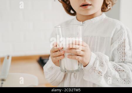 Petite fille préparant de la pâte pour des crêpes à la cuisine. Concept de préparation des aliments, concentration sélective, gros plan sur les détails. Style de vie décontracté photo ser Banque D'Images