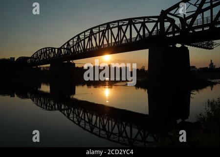 Le reflet de l'ancien pont sur la rivière, la silhouette du vieux pont au lever ou au coucher du soleil dans le campagne Banque D'Images