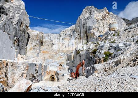 Exploitation minière en fonte ouverte dans une carrière de marbre de Carrara montrant la face rocheuse et les machines lourdes en Toscane, en Italie Banque D'Images