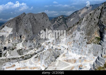 Carrières de marbre de Carrara dans une vallée de montagne dans le nord de la Toscane, Italie montrant l'exploitation minière à ciel ouvert avec des faces de roche en terrasse dans un paysage industriel Banque D'Images