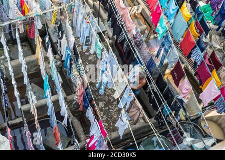 Mumbai, Inde - 22 novembre 2019 : un homme raccroche sa blanchisserie pour sécher dans le quartier de la blanchisserie de Dhobi Ghat, une laverie en plein air bien connue dans le centre-ville, Mhumb Banque D'Images