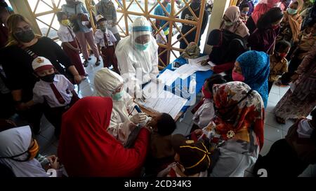 (200826) -- JAKARTA, 26 août 2020 (Xinhua) -- UN agent de santé vérifie l'état d'un étudiant du primaire avant de lui donner un vaccin contre la rougeole et la rubéole (MR) dans le contexte de l'épidémie de COVID-19 à Jakarta, en Indonésie, le 26 août 2020. Les vaccins contre la rougeole et la rubéole (MR) sont administrés aux jeunes dans le cadre du programme du gouvernement indonésien visant à offrir une vaccination appropriée des enfants à l'école. (Xinhua/Agung Kuncahya B.) Banque D'Images