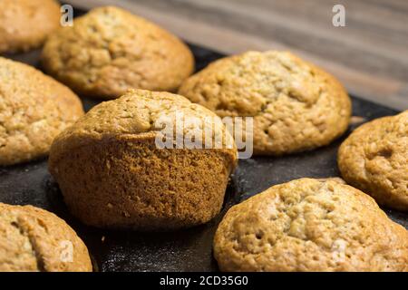 Muffins cuits dans un moule à pâtisserie sur le plan de travail de la cuisine - mise au point sélective Banque D'Images
