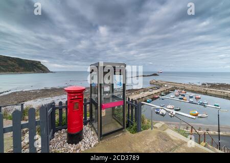 GARDENSTOWN, ÉCOSSE - 2016 OCTOBRE 22. Ancienne boîte postale rouge anglaise et une boîte téléphonique au-dessus du port de Gardenstown. Banque D'Images