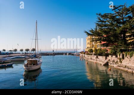 Petit port touristique avec bateaux privés sur le lac de Garde, Sirmione, Brescia, Italie. Banque D'Images