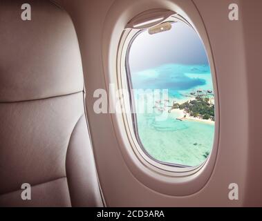 L'intérieur de l'avion avec fenêtre vue de l'île des Maldives. Concept de voyage et du transport aérien Banque D'Images